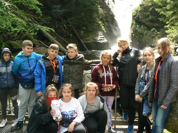 Uczniowie na dwudniowej wycieczce uczniowie pozują przy wodospadzie